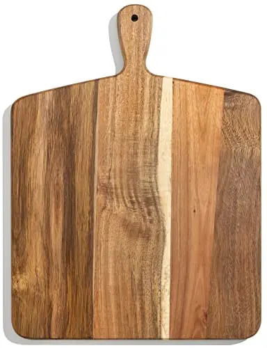 Home Beets rectangular acacia wood cutting and serving board with handle on a kitchen counter.