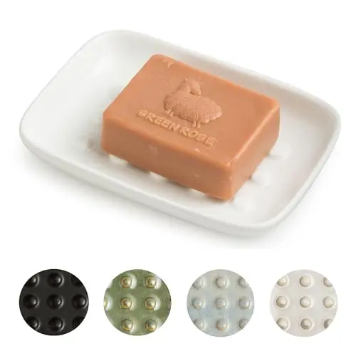 A white ceramic soap dish with a raised floating point design for drainage and a wide, stable base.